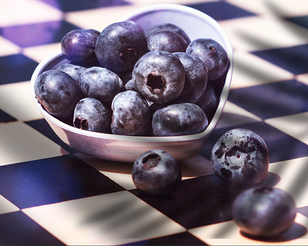 Blåbär i hjärtformad skål på rutigt bord - blåbär kan lindra artros